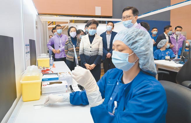 大陸防疫專家張文宏表示，須在接種疫苗、國際疫情兩條件都達要求下，明年下半年才可能看到摘口罩。圖為10日香港特首林鄭月娥到中山紀念公園體育館社區疫苗接種中心視察。（中新社）