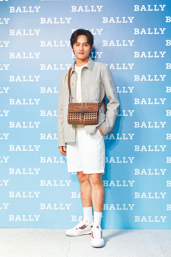 范少勳身穿白色套裝，手拿Bally Vestige系列雷射牛皮1851裝飾斜肩包6萬9000元、KUBA紅白運動鞋1萬7600元。（Bally提供）