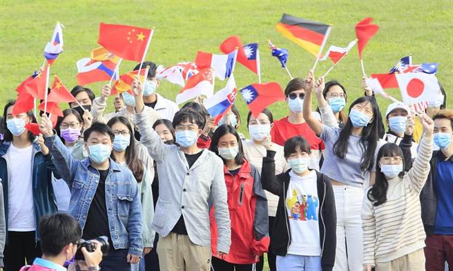 「東吳大學建校121年校慶典禮暨運動大會」13日舉行，國際與兩岸學術交流事務處的同仁揮舞包括中國五星旗等各國旗幟。（張鎧乙攝）