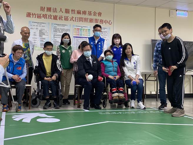 蘆竹區嘻皮廬日照中心13日揭牌，有教練與裁判證的體大應屆畢業腦麻生張亦辰（右一），指導桃園市長鄭文燦（右四）等人體驗地板滾球運動。（蔡依珍攝）