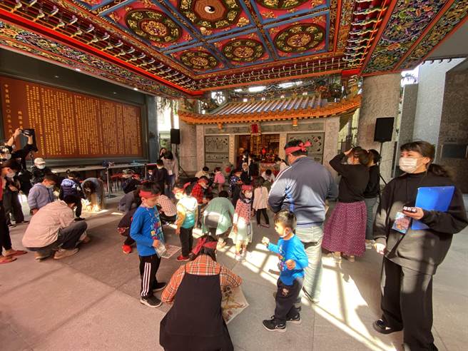 大小朋友勇闯「踩报纸黏牢牢」。(蔡依珍摄)