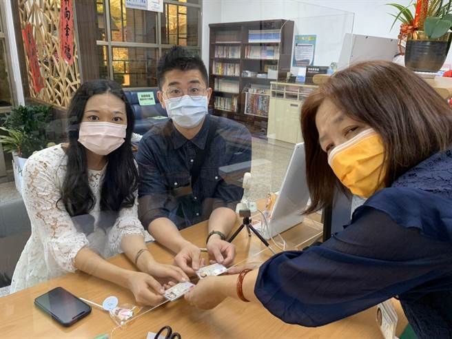 台中市霧峰戶所戶籍員吳秋燕（右）親自為擔任警察的兒子完成結婚登記，感到非常高興。（台中市府提供／盧金足台中傳真）
