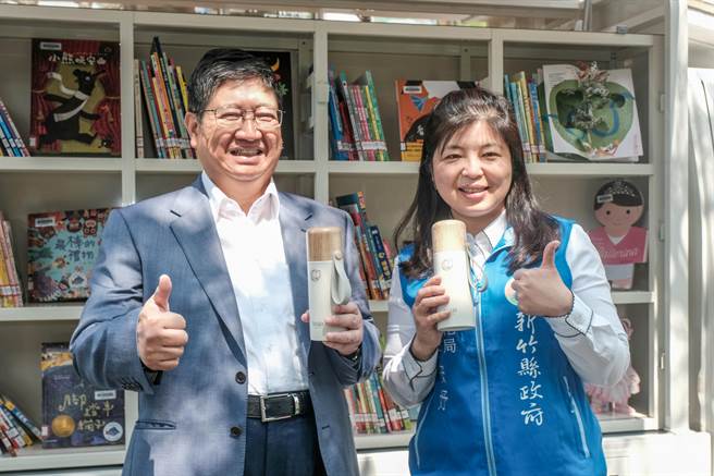縣長楊文科（左）和文化局長李安妤（右）指大小朋友參加「跟風閱讀‧悠遊竹縣」6大主題活動，只要集滿4大主題活動印章，就能換精美好禮「木紋保溫杯」。（羅浚濱攝）