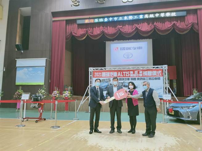 国瑞汽车吴梵副理将象徵车辆捐赠的钥匙看板赠与学校，由李真玲与周文松代表接受，并回赠感谢状与水晶奖牌纪念品。（东势高工提供／陈淑娥台中传真）