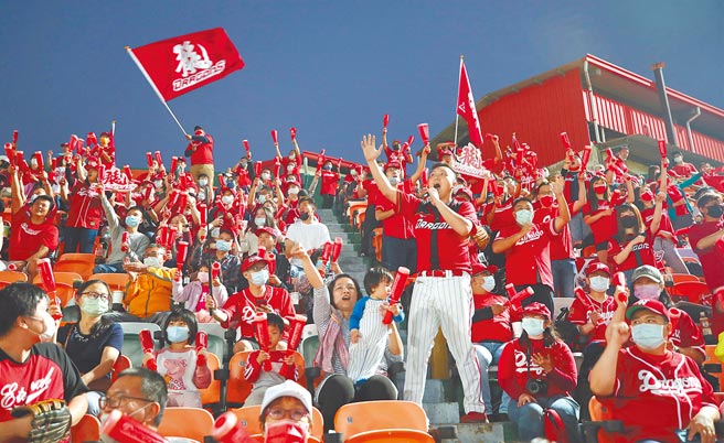 台南棒球場「龍獅大戰」為味全龍隊回歸一軍首戰，吸引許多龍迷進場觀戰，賣力揮舞旗幟應援加油。（中央社）