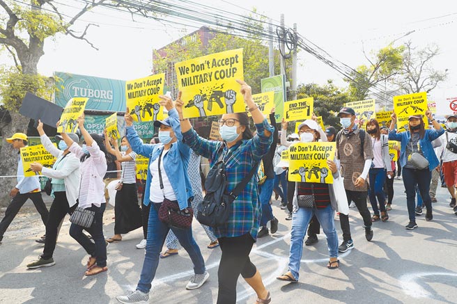 緬甸軍政府昨天緊急宣布擴大在仰光戒嚴的範圍。台廠昌億也在暴亂中遭池魚之殃。圖為緬甸反對政變的民眾在瓦城舉標語示威。（美聯社）