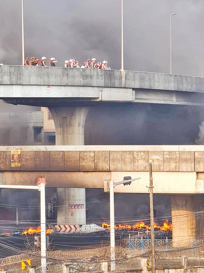 緬甸抗議政變失控轉成暴亂，昨日在仰光抗議民眾在多處縱火。台資廠也未能倖免。圖為緬甸出動安全部隊，趕往遭到縱火的地區。（路透）