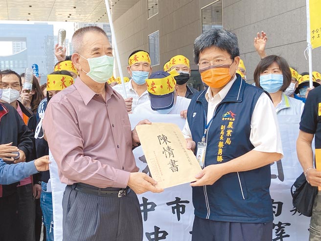 台中市家畜肉类商业同业公会理事长张国梁（左）与200多名肉商、屠宰业15日到市府抗议，由农业局副局长蔡勇胜出面接下陈情书。（卢金足摄）