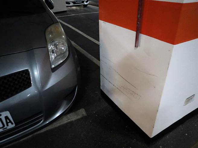 车格线画在梁柱后方，墙面遗留车辆擦撞痕迹。（王文吉摄）