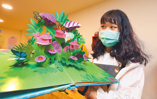 家扶基金会指出，扶助童在2015年前人数皆逐年上升，但受到少子女化影响，2015年后逐年下降、2019年达4万7894人，儿童数成长率每年约减少1％。图为亚洲首座立体书庇护工场，1名工作人员正在展示制作精细的立体书。（范扬光摄）