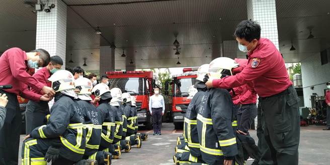 師父幫徒弟戴上消防帽。（新北市消防局提供）