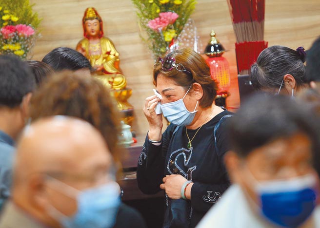 新店復兴里长刘洪珠（中）17日前往第二殡仪馆，在死者灵位上香致意后，频频拭泪。（范扬光摄）