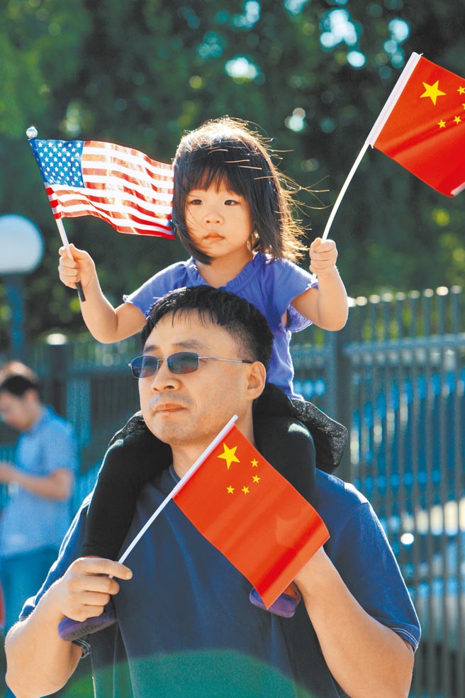 中美国安外交高层2+2战略对话，18、19日在阿拉斯加登场。图为2013年休士顿华人手举两国国旗参加十一国庆相关活动。（新华社）