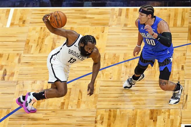 篮网后卫哈登想要运球突破魔术前锋阿隆戈登的防守。(美联社)