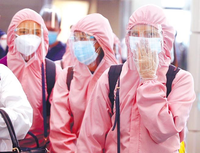 疫情指挥中心19日公布国内新增6例境外移入确定病例，累积确诊已经破千例，其中3例来自菲律宾。图为一群菲籍移工搭机抵达桃园机场，准备通关入境。（范扬光摄）