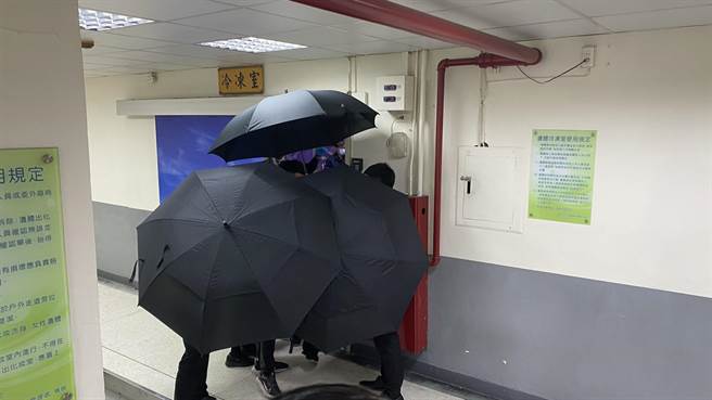 死者家属进入遗体冷涷室内认尸，看到挚爱亲人烧成焦黑，忍不住痛哭失声。（王文吉摄）