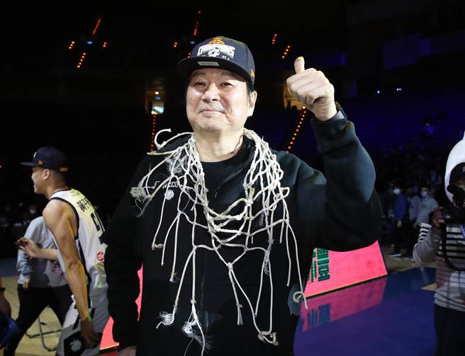 政大男篮的推手领队姜丰年，开心挂上剪下的冠军篮网拍照纪念。（郑任南摄）