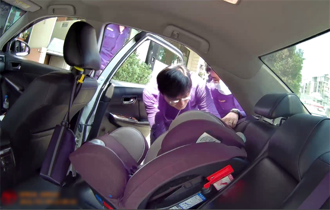 派出所奶爸警察研究調整兒童座椅，成功完成安裝，林女頻頻致謝，終於可以安心帶小孩上路。（民眾提供／盧金足台中傳真）