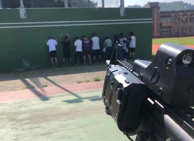 台中市立丰原高中课程使用「水弹枪」教具，让学生持枪对准整排面墙的同学，做出疑似「处决」动作引发争议。（摘自爆料公社）