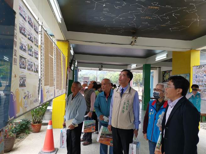 二溪国小校长陈庆林（右）为校友来宾介绍时光迴廊老相片展内容。（刘秀芬摄）