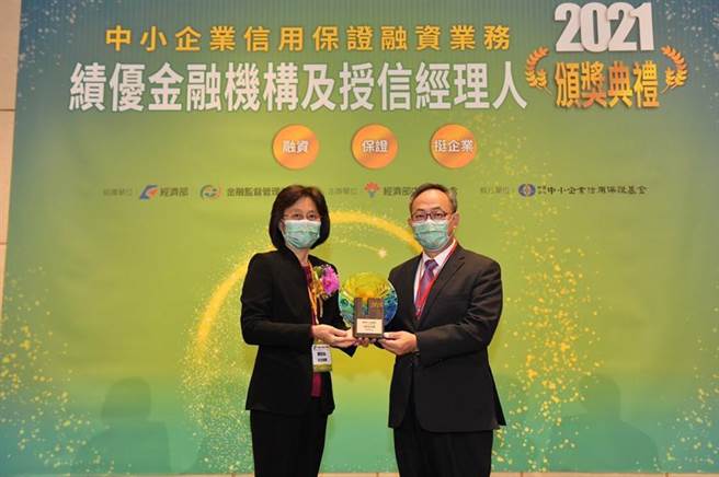 臺灣企銀總經理張志堅(右)代表接受經濟部主任秘書陳怡鈴(左)頒授「信保金質獎」獎座。（圖／臺灣企銀提供）