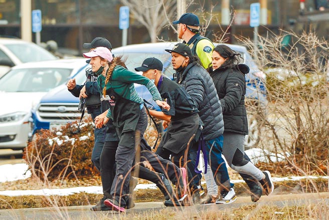 科羅拉多圓石市的金蘇柏超市2日下午發生槍擊慘案，至少10人死亡。圖為槍擊發生時，超市員工在警方保護下倉皇走避。（路透）