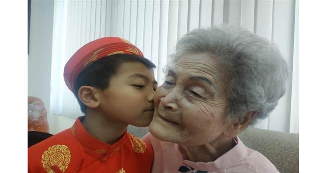 越南新住民潘錦秀7 歲兒子和高齡 100 歲阿祖開心合影。（圖/社團法人宜蘭縣宜萱婦幼關懷協會提供）

