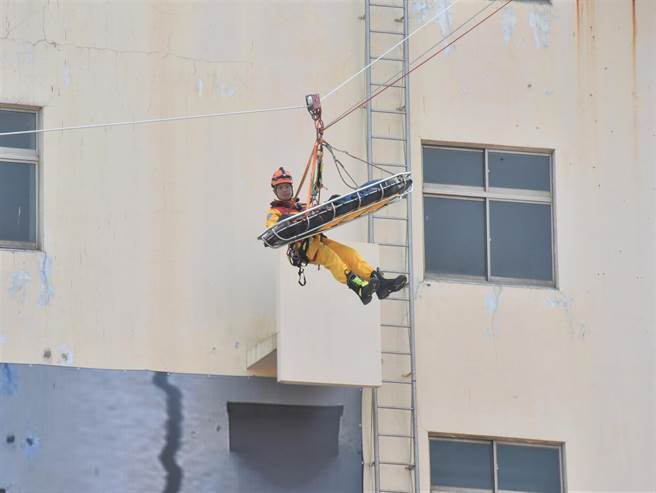高雄市政府25日在楠梓区举行民安七号灾害防救演习，消防局人员模拟高空救护。（林瑞益摄）