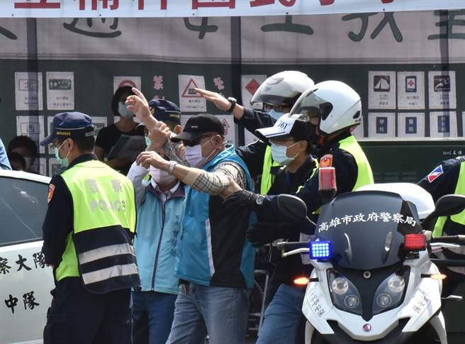 高雄市政府25日在楠梓区举行民安七号灾害防救演习，模拟民眾不配合迁移，警方配合当地里长劝退民眾，并将他带离灾害现场。（林瑞益摄）