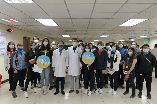 長庚醫院副院長李建德（右）、林孟志（左）迎接選手施打新故肺炎疫苗，空手道文姿云（前排左三）、舉重郭婞淳（前排左七）都第1劑施打完畢。（國訓中心提供）