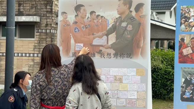 F-5E殉职飞官罗尚桦灵堂设置在台东市立殡仪馆，同事制作「国军英雄我想对祢说」的留言板及其生活剪影，罗妻（中）缓缓将字条贴在留言板上最醒目的一处。（蔡旻妤摄）