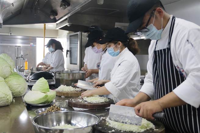 弘光餐旅系學生獲贈上百斤高麗菜，發揮巧思拿來包高麗菜水餃義賣助弱勢。（陳淑娥攝）