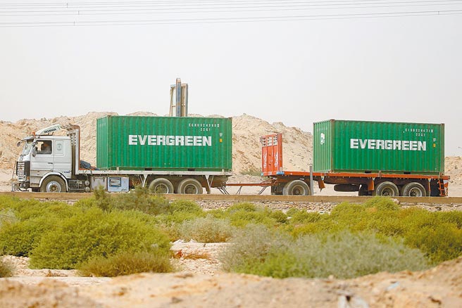 长荣海运的长赐轮塞在苏伊士运河，一夕间成了全球焦点，图为一辆装有长荣货柜的卡车行驶赴港口。（路透）