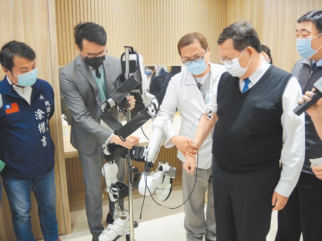 桃园市长郑文灿（右一）体验復健机器人，用意念让器材动作。（邱立雅摄）