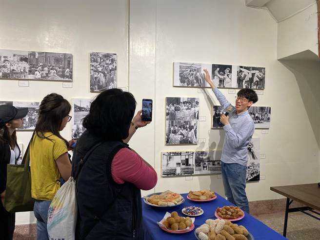 七星药局第三代药师吴至铠（右）带大家认识从1900年代、日治时期的民雄，到大士爷祭典真人艺阁等珍贵的老照片。（张亦惠摄）