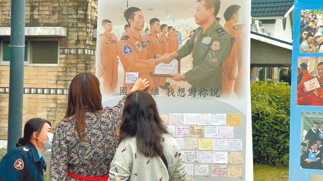 F-5E殉职飞官罗尚桦灵堂设置在台东市立殡仪馆，树立追思留言板及其生活剪影，罗妻（中）将「这辈子太短，我们下辈子再续」字条贴在留言板上，令人不舍。（蔡旻妤摄）
