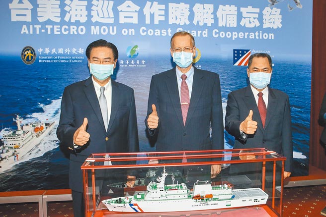 美國在台協會（AIT）及駐美國台北經濟文化代表處（TECRO）於美東時間3月25日簽署了成立海巡工作小組（CGWG）備忘錄。外交部26日舉辦「台美海巡合作瞭解備忘錄」宣布茶會，外交部長吳釗燮（左）、海委會海巡署署長周美伍（右）、美國在台協會（AIT）處長酈英傑（中）等人出席，並在海巡署嘉義艦CG5001模型合影留念。（鄧博仁攝）