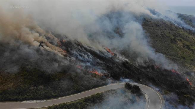 苗栗县消防局第4大队指出，28日上午10时30分许，通霄镇秋茂园对面发生公墓火警，浓烟夹火舌覆盖山林，消防人员抢救中。（苗栗县消防局提供）