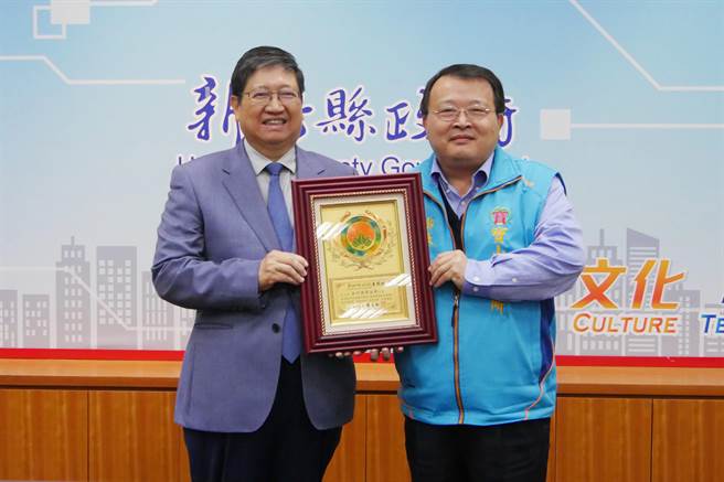 寶山鄉立圖書館獲得教育部3項肯定，縣長楊文科（左）頒給寶山鄉長邱坤桶（右）表揚狀鼓勵。（羅浚濱攝）