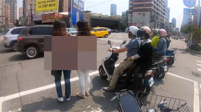 兩名路人因聊天太忘我，竟進入機車待轉區內等紅燈。（翻攝路上觀察學院臉書）