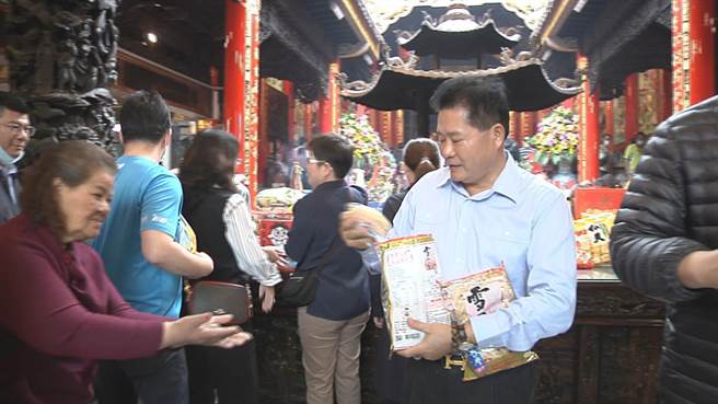 大甲镇澜宫副董郑铭坤将旺旺仙贝分给妈祖信徒享用。（中天电视提供／陈淑娥台中传真）
