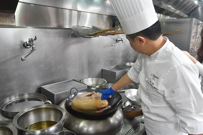 厨师「碌」鹅时必须不停翻转滚动鹅身，注意油温和鹅胚变化，非常耗费时间和精力。(图／姚舜)