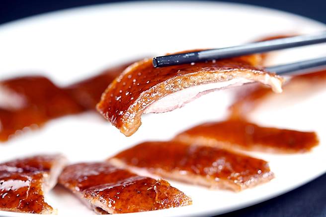 〈晶华轩〉的〈片皮鸭〉，鸭皮油光旺汪、红润酥脆，鸭肉柔嫩。（图／姚舜）