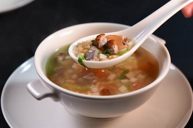 〈火鸭泡饭〉滚烫的汤底中有带皮鸭肉、青江菜、番茄丁、绿竹笋丁与油葱。（图／姚舜）