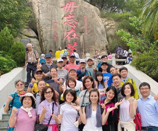 遊客與空姐在「毋忘在莒」勒石合影，開心表示這是一趟很特別的金門之旅。（聖祖食品提供）