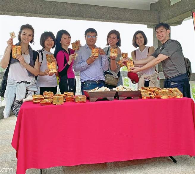 空姐客串「美食推銷員」與遊客分享當地名產貢糖、牛肉乾之一。（聖祖食品提供）