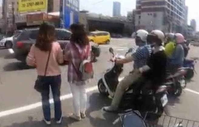 兩位女生直接走進機車待轉區中，站著繼續聊天。（擷自「路上觀察學院」）