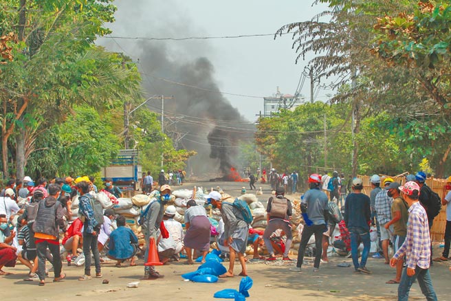 儘管前一天有超过100人遭军警杀害，缅甸各地反政变示威人士28日仍走上街头。图为民眾在仰光街头设置路障，对抗军警镇压。 （美联社）