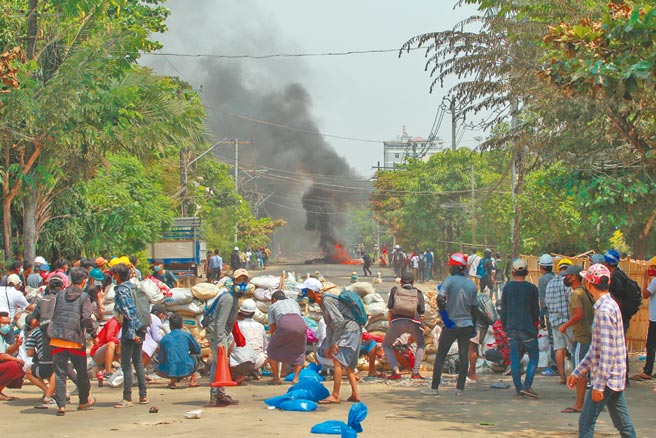 緬甸各地反政變示威人士28日仍走上街頭。圖為民眾在仰光街頭設置路障，對抗軍警鎮壓。 （美聯社）