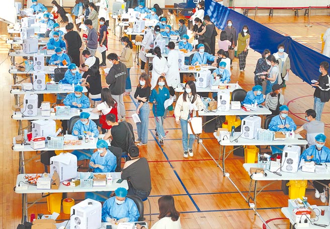 大陸至27日已接種破億劑次疫苗，目前每天施打600多萬劑，全力提高施打率。圖為在上海華東師範大學閔行校區體育館內，師生們接種新冠疫苗。 （新華社）